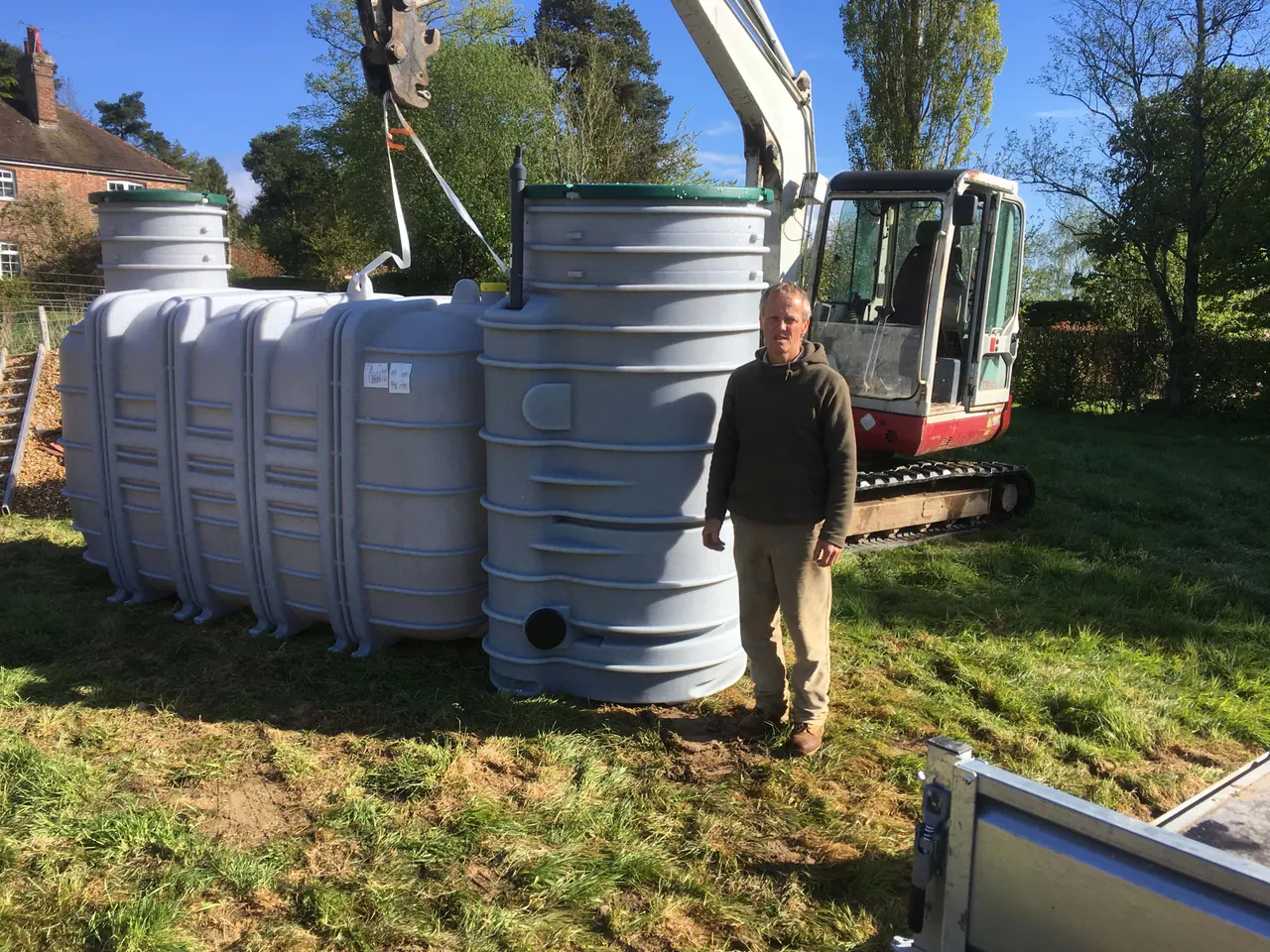 Mark Humphries beside a treatment plant and excavator on an installation site